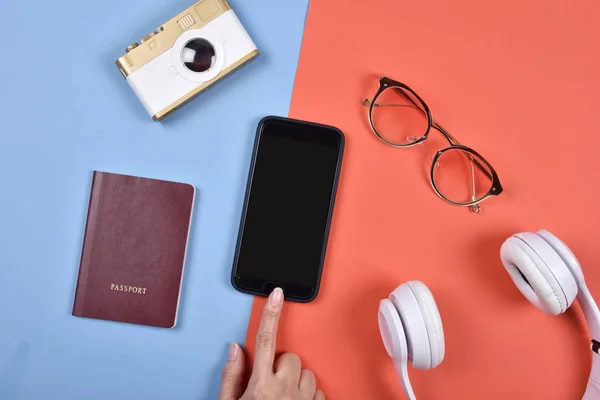 Essentials Reisvoorbereiding, Hand leeg smartphone scherm aan te raken voor mock-up, reizen-accessoires, mobiele telefoon, paspoort, digitale camera, bril en hoofdtelefoon. — Stockfoto
