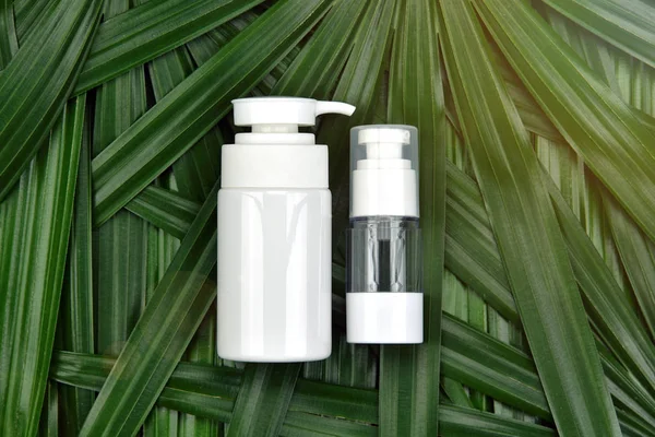 Φυσικό skincare έννοια προϊόντων ομορφιάς, Καλλυντικά μπουκάλι δοχεία για πράσινο φυτικό αφήνει φόντο, λευκά label για branding μακέτα. — Φωτογραφία Αρχείου