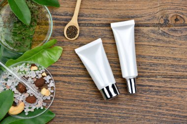 Kozmetik şişe kapları ile yeşil bitki yaprakları, marka mock-up, doğal organik güzellik ürün kavramı için boş etiket paketi.