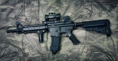 Silah ve askeri teçhizat ordusu, taarruz tüfeği topu (M4a1) ve kamuflaj arka plan üzerinde tabanca.