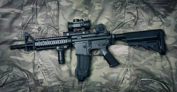 Silah ve askeri teçhizat ordusu, taarruz tüfeği topu (M4a1) ve kamuflaj arka plan üzerinde tabanca.