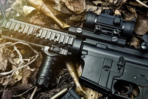 Armas e equipamentos militares para o exército, Close up of assault rifle gun (M4A1) e pistola em folhas secas fundo floresta . — Fotografia de Stock