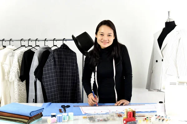 Designer de moda asiática trabalhando em seu estúdio showroom . — Fotografia de Stock