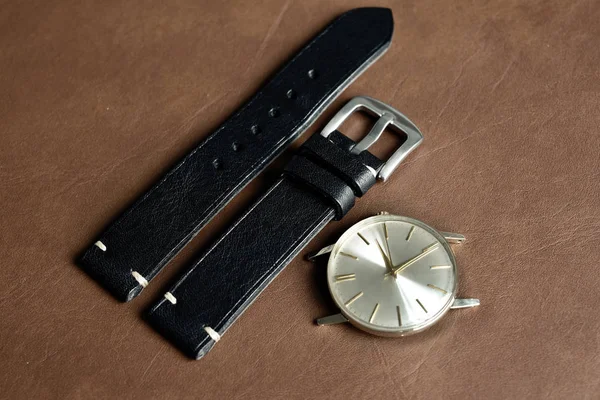 Vintage armbandsur på en brun läder bakgrund. Klassiska klock remmar, äkta hantverk italienska kalvskinn med vit topp sömnad. — Stockfoto