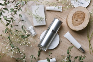 Yeşil bitkisel yapraklarla paketlenmiş kozmetik şişe kapları, organik markalaştırma için boş etiket, doğal cilt bakımı ürün konsepti.