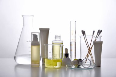 Dermatologist formulating and mixing pharmaceutical skincare, Cosmetic bottle containers and scientific glassware, Research and develop beauty product concept.