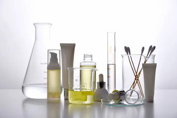 Dermatolog formułowanie i mieszanie farmaceutycznej pielęgnacji skóry, Pojemniki na butelki kosmetyczne i szkła naukowego, Badania i opracowanie koncepcji produktu kosmetycznego. — Zdjęcie stockowe