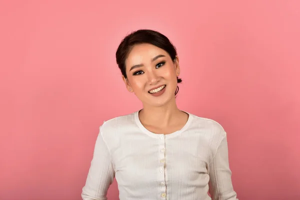 美丽的亚洲女人在粉红的背景上放松 穿着休闲装的快乐微笑的女孩在镜头前的画像 — 图库照片