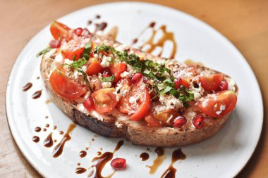 Taze domatesli kızarmış ekmek, feta peyniri ve nar, sağlıklı organik yemek..