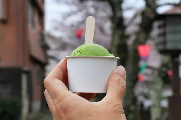 Green tea matcha ice cream over tourist attraction walking street background, Favorite traditional ice cream flavor in japan.