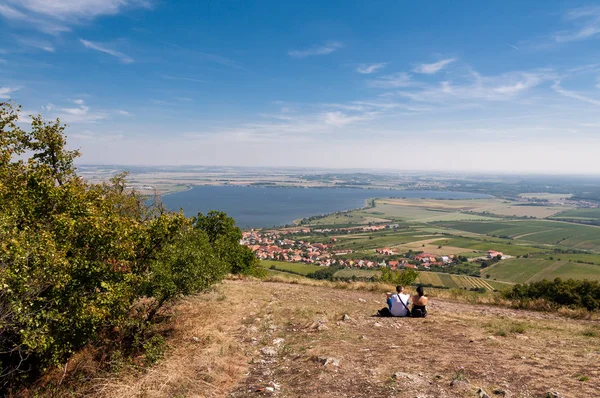 Bağ yakınlarında küçük bir köy, mavi gökyüzü, tarım ve şarap. Erkek ve kız ön planda.