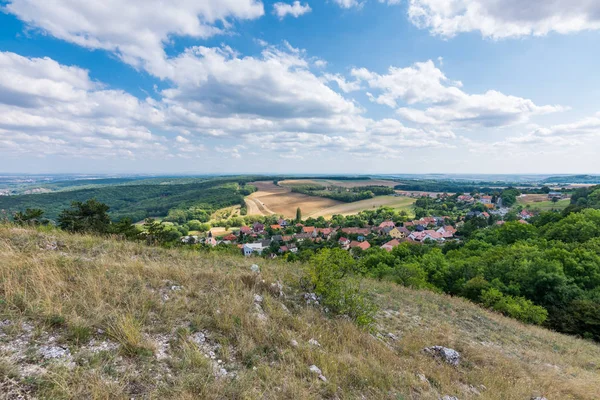 Küçük bir köy, çayır ve tarım manzara görünümü. Orman yeşil ağaçlar, mavi gökyüzü, bulutlar ile sağ tarafında
