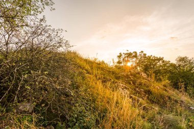 Günbatımı manzara panorama, altın saat tepelerde, Vadisi, güzel renkler ve bulutlar küçük köyde.