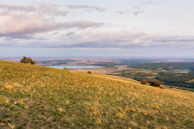 Günbatımı manzara panorama, altın saat tepelerde, Vadisi, güzel renkler ve bulutlar küçük köyde.