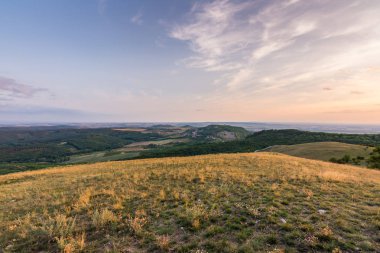Günbatımı manzara panorama, altın saat tepelerde, Vadisi, güzel renkler ve bulutlar küçük köyde.