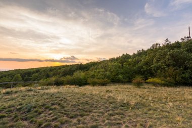 Günbatımı manzara panorama, altın saat tepelerde, Vadisi, güzel renkler ve bulutlar küçük köyde.