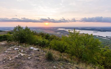 Günbatımı manzara panorama, altın saat tepelerde, Vadisi, güzel renkler ve bulutlar küçük köyde.