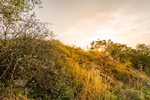 Günbatımı manzara panorama, altın saat tepelerde, Vadisi, güzel renkler ve bulutlar küçük köyde.