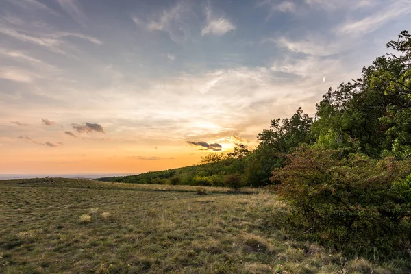 Günbatımı manzara panorama, altın saat tepelerde, Vadisi, güzel renkler ve bulutlar küçük köyde.