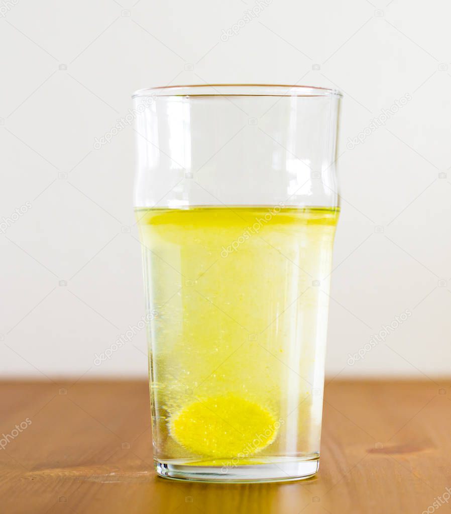Effervescent tablet and glass of water. Vitamin beverage.