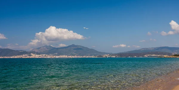 Corsica beach yukarıda uçak fly. Ajaccio şehir Corsica Dağları ile arka planda.