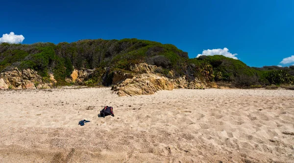 Torba turystyczna z buty na plaży. Trawa i bukiety w tle. Egzotyczne tropikalne krajobrazy — Zdjęcie stockowe