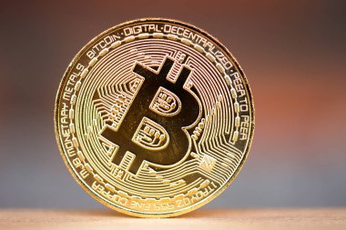 Brick kırmızı arka plan ile ahşap masa üzerinde altın bitcoin jeton yerleştirilir. Sanal cryptocurrency sembolü.