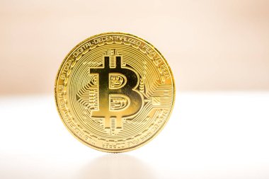 Bitcoin altın sikke beyaz ve kahverengi zemin üzerine yerleştirilir. Cryptocurrency altın sikke.