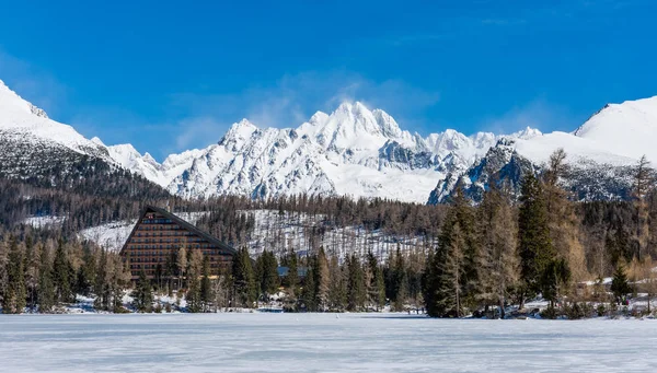 Slovakia, Strbske Pleso: View of frozen lake in Big Tatra, Slovakia. Mountains in background, the trees and lake in foreground. Winter and snow. Sport vacation and tourism. — Stock Photo, Image