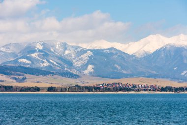Slovakya: Tatra mountain yakınındaki küçük bir köy. Liptovska Mara göl ön planda. Kış ve kar dağ.