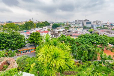 Tayland 'ın Bangkok şehrinin Panorama manzarası. Şehirdeki yerleşim yerleri ön planda, tapınaklar, gökdelenler ve modern binalar. Taze ağaçlar ve bitkiler. Bulutlu hava, dramatik bulutlar.
