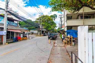 Chiang Mai, Tayland - 4.11.2019: Chiang Mai şehrinde sokak. Arabalı sokak manzarası, ahşap evler, ağaçlar. Ortadaki yolu daralt