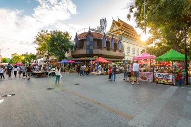 Chiang Mai, Tayland - 3.11.2019: Günbatımından kısa bir süre sonra Chiang Mai şehrinde gece pazarı. Turistler yolda yürüyorlar. Yandaki tezgahta Taylandlı satıcılar var. Hatıralar ve sokak yemekleri, yaz günü.