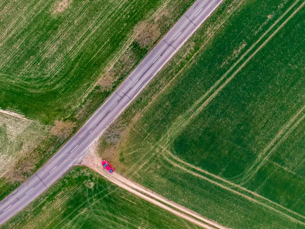 Rode Auto Parkeren Het Groene Veld Buurt Van Asfaltweg Bovenaanzicht — Stockfoto