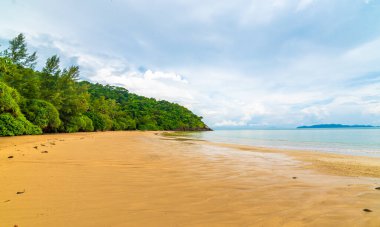 Tayland 'daki Mu Ko Lanta Ulusal Parkı' ndaki plaj manzarası. Taze yeşil ormanın yanındaki sahil, sıcak kum ve saf mavi su. Bulutlu hava, yaz günü. Ünlü gezginlerin gideceği yer.
