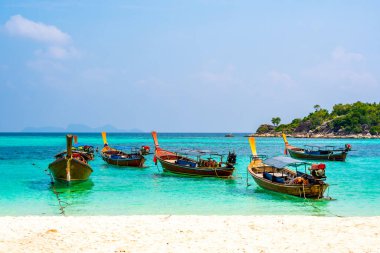 Tayland 'ın güneyindeki Ko Lipe adasında küçük limandaki uzun kuyruk tekneleri. Tropik ve egzotik ada, Tarutao Ulusal Doğa Parkı 'nın bir parçası olan tropik cennetin sembolüdür. Canlı renkler, turkuaz su.