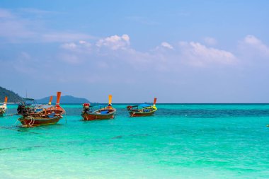 Tayland 'daki Ko Lipe adasında uzun kuyruk teknesi. Beyaz kum, sahil ve turkuaz deniz ile tropik ada Tarutao Ulusal Deniz Parkı 'nın bir parçasıdır. Idyllic tatil, cennette rahatlama.