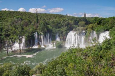Beautiful view of the Kravica waterfalls after heavy rains. Large tufa cascade on the Trebizat River, in the karstic heartland of Herzegovina. Lush surrounding and rich riparian ecosystem. Nature and travel. Bosnia and Herzegovina