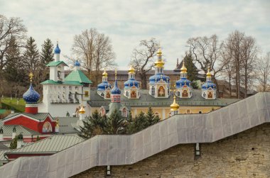 Pskov-Caves Manastırı (Pskovo-Pechersky Dormition Manastırı veya Pskovo-Pechersky Manastırı). Kale duvarı. Şefaat Kilisesi 'nin kubbeleri. Bell Gable, kutsal eşya deposu. Rusya, Pskov Oblağı, Pechory