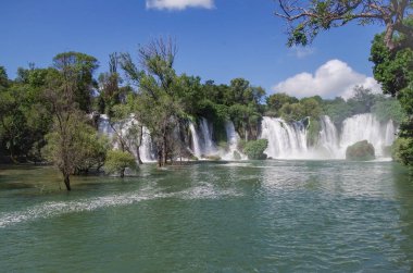 Beautiful view of the Kravica waterfalls after heavy rains. Large tufa cascade on the Trebizat River, in the karstic heartland of Herzegovina. Lush surrounding and rich riparian ecosystem. Nature and travel. Bosnia and Herzegovina
