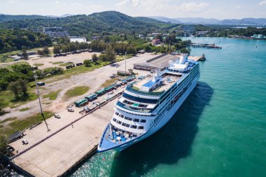 PHUKET, THAILAND - APRIL 16 : Big cruise ship 'Insignia' standing at the harbour on April 16, 2017 in Phuket, Thailand. Aerial view from flying drone clipart