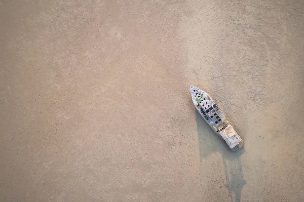 Gran barco de pesca viejo de pie en el mar de barro. Vista aérea desde el avión no tripulado volador — Foto de Stock