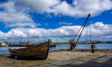 Orkney Quayside with clouds and a boat clipart