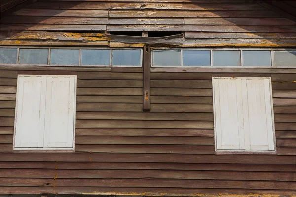 Een klein venster in de muur van een oud houten huis — Stockfoto