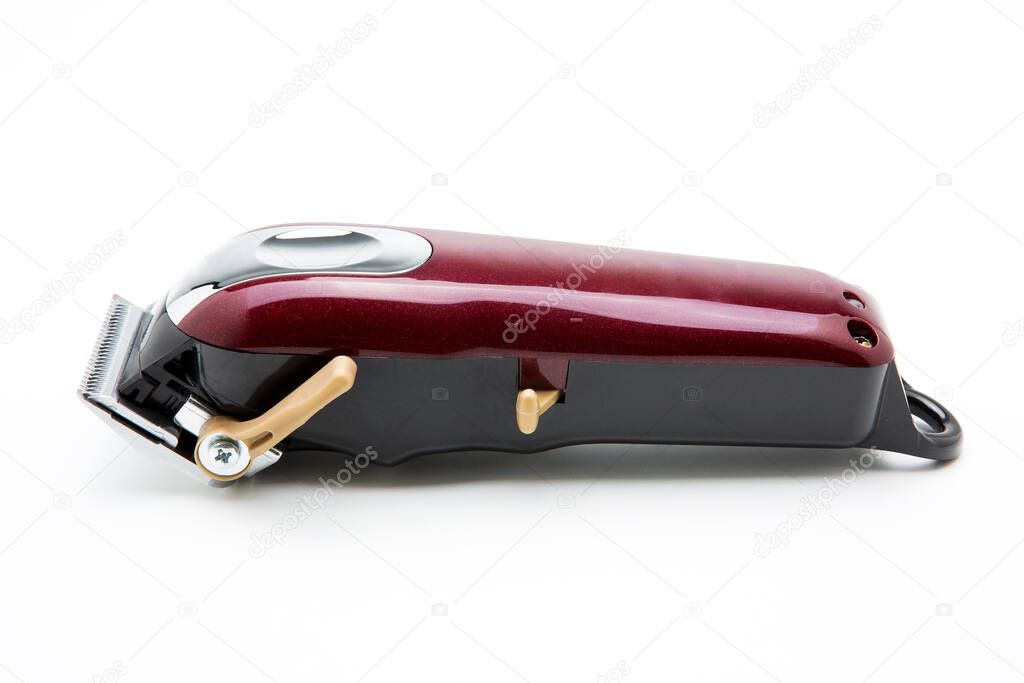 Red clippers for cutting hair on a white background