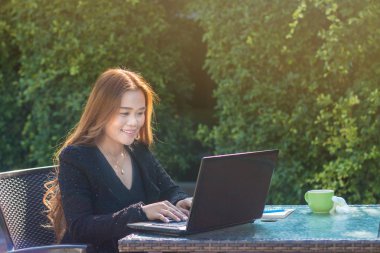 Asyalı genç kadın ile dizüstü bilgisayar kullanarak