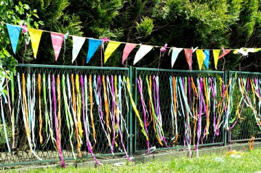Renkli kağıt şeritler ve bir çit asılı bayrakları
