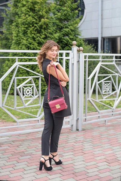Joven empresaria con un bolso rojo cerca de la oficina — Foto de Stock