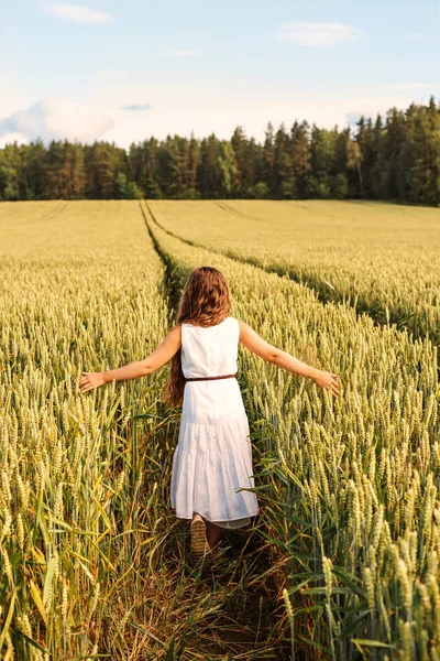En tjej går på fältet vete — Stockfoto