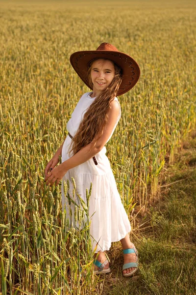 En flicka på fältet vete i en cowboyhatt — Stockfoto